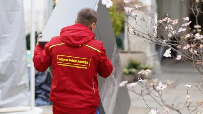 Umzugshelfer transportiert Gegenstand