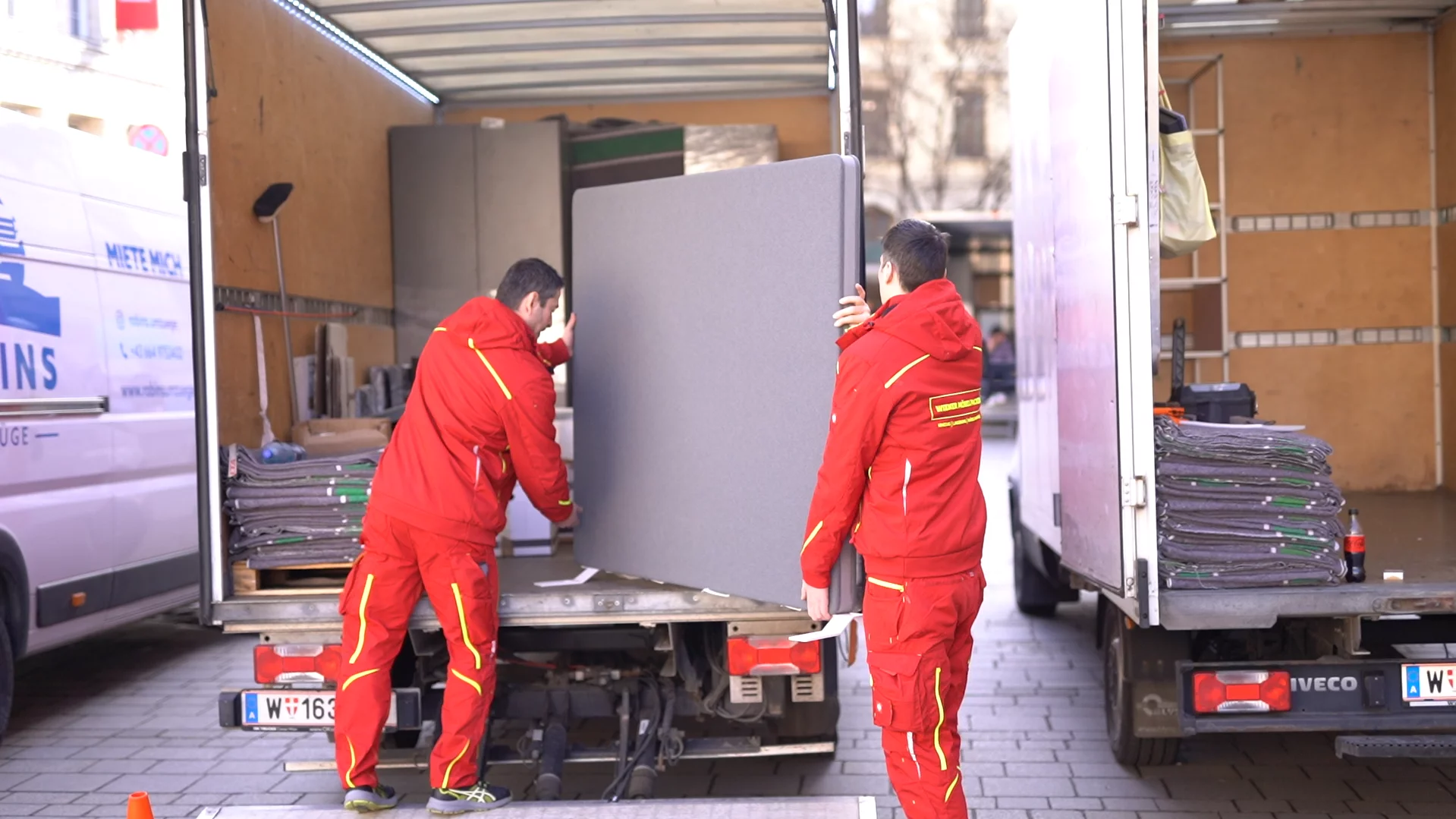 Wiener Möbelpacker transportieren Schwerlast aus Transporter